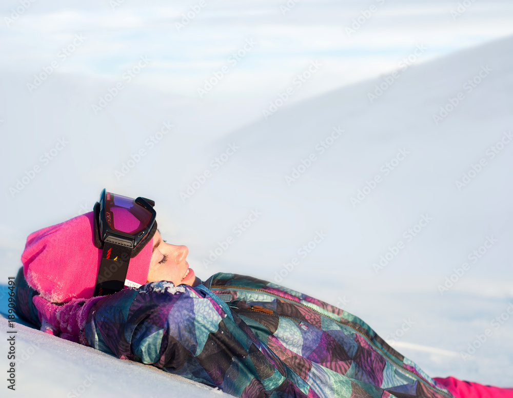 在冬季风景的背景下，穿着滑雪服的可爱微笑女孩