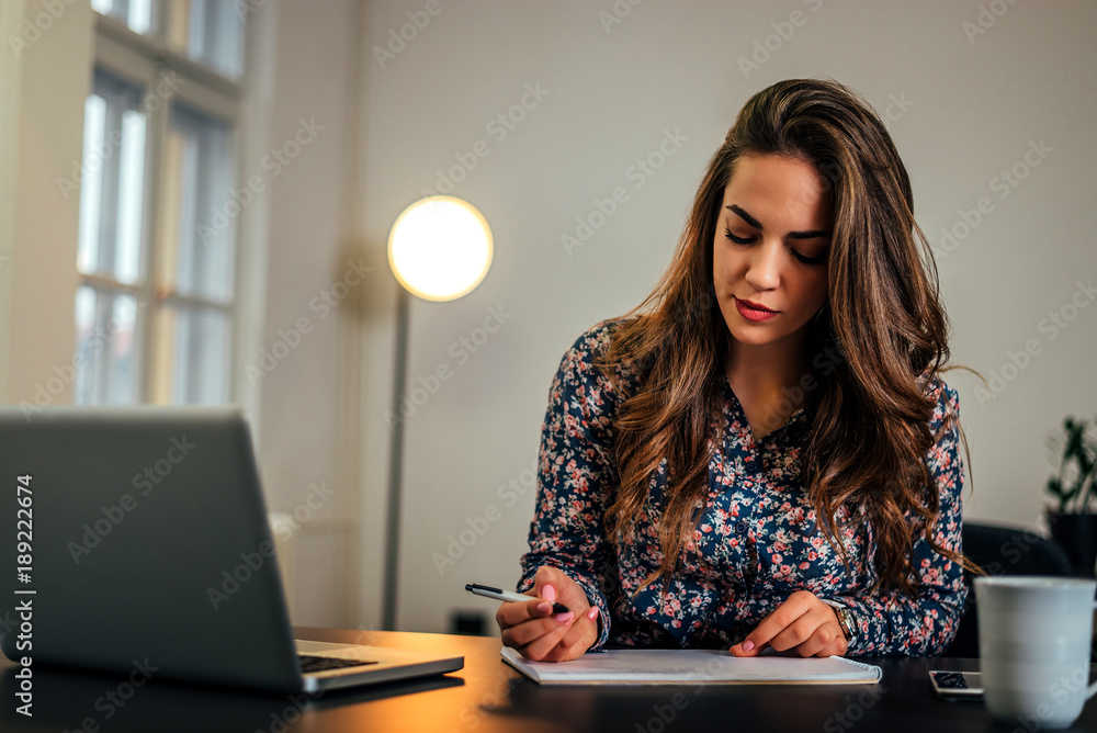 Beautiful woman preparing for new project, writing notes.