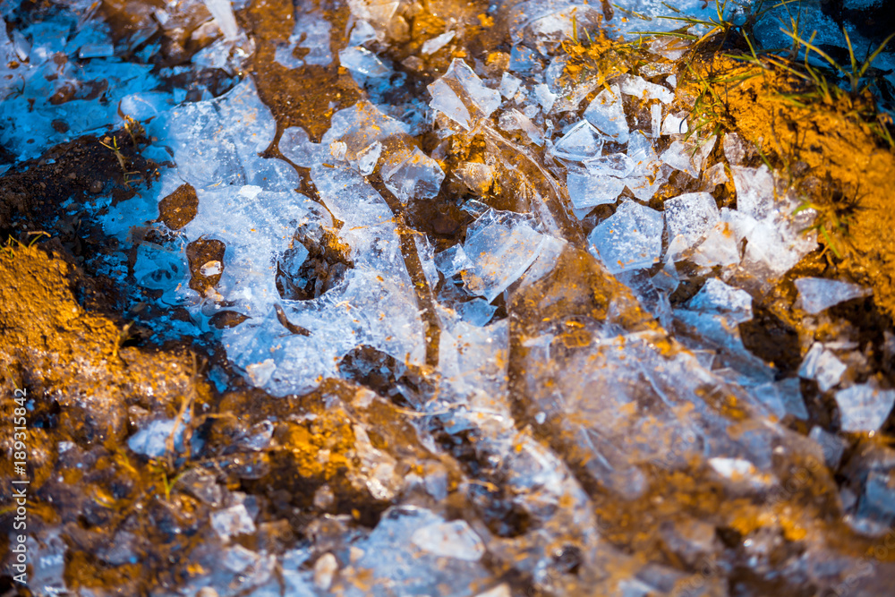 Frozen puddle, muddy ice ground top view