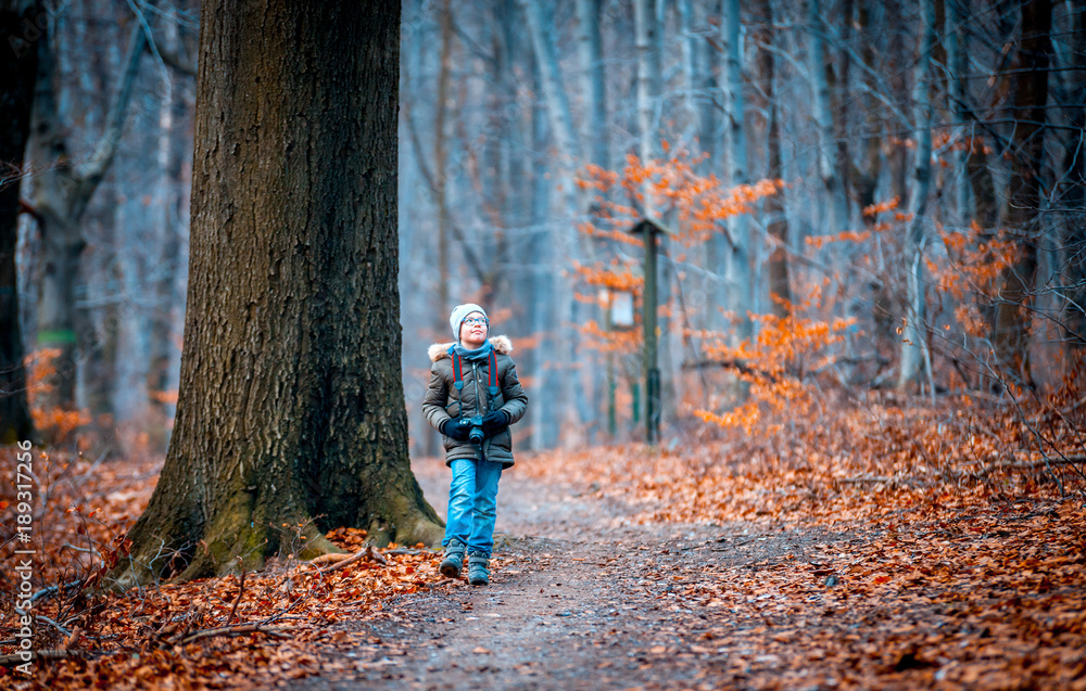 Boy with digital camera walking in the nature, hobby concept