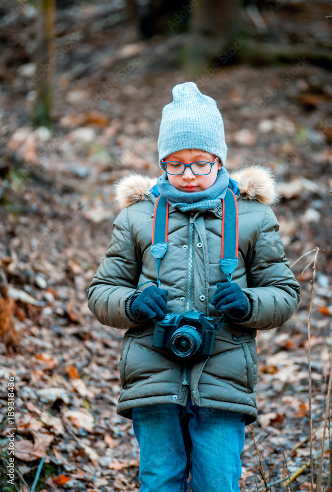 Boy using digital camera taking photo in the nature, hobby concept