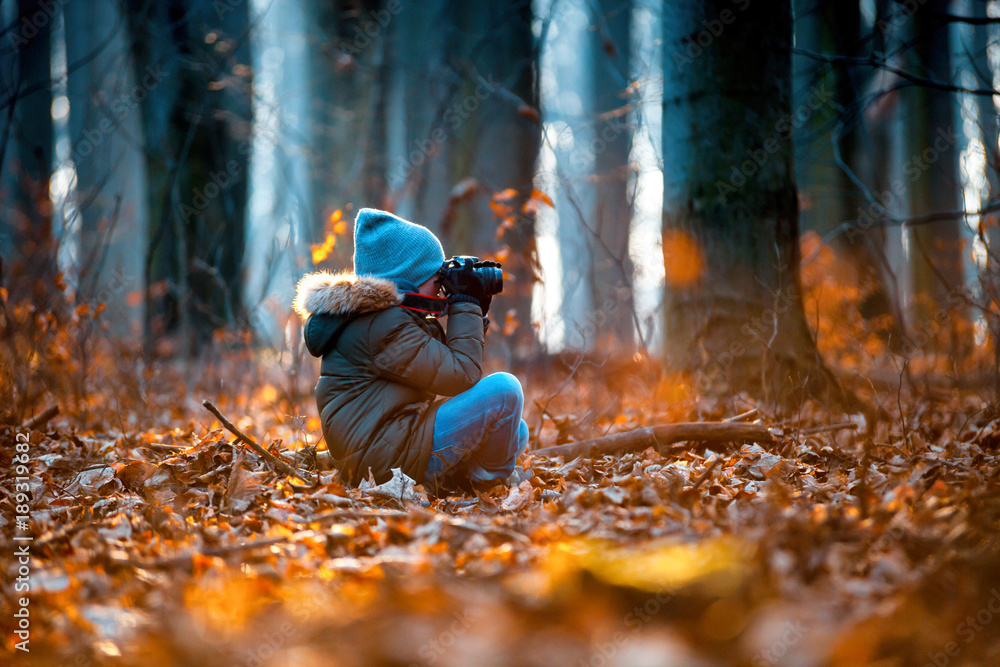 Boy using digital camera taking photo in the nature, hobby concept