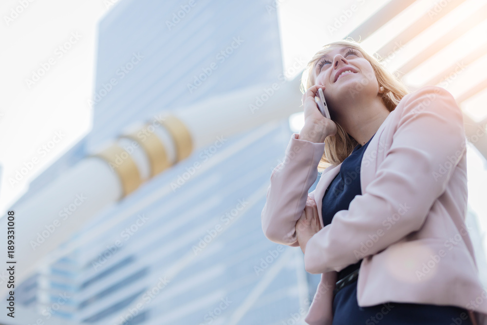 smart caucasian businesswoman hand hold smartphone with blur background of urban city background bus