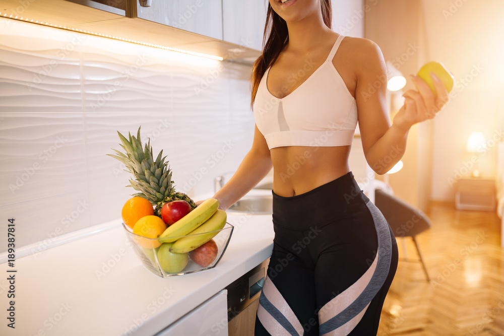 Cropped shot of young woman eating fruit for breakfast.