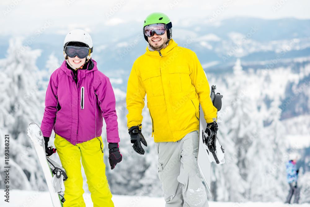 一对年轻夫妇寒假在雪山上滑雪板行走