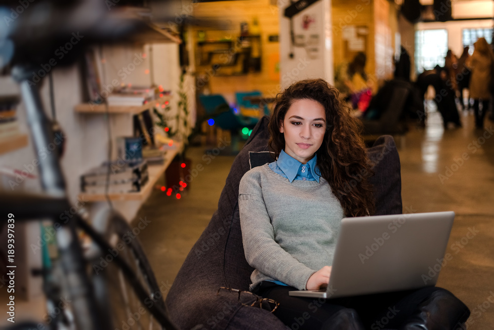 Beautiful woman writing her fashion blog on laptop.