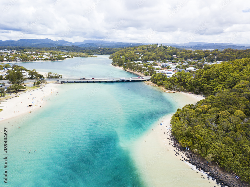 Tallebudgera Creek河口的航拍照片，图框右侧为Burleigh Heads。金色C