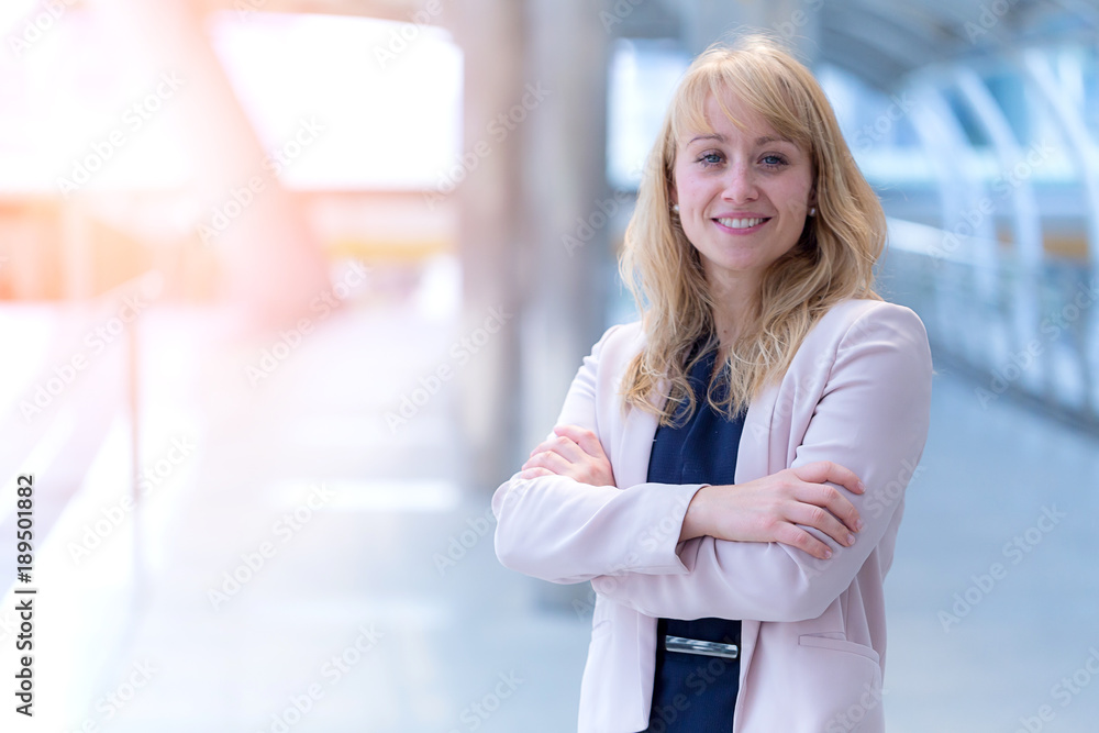 smart and confident caucasian businesswoman smile and standing with city building background