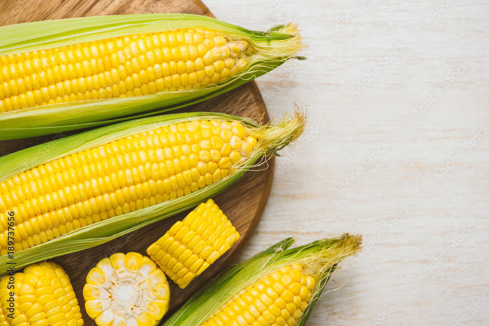 Sweet corns. Fresh corn on cobs on wooden table.