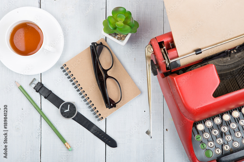 Writer or journalist workplace - vintage red typewriter on the white wooden desk