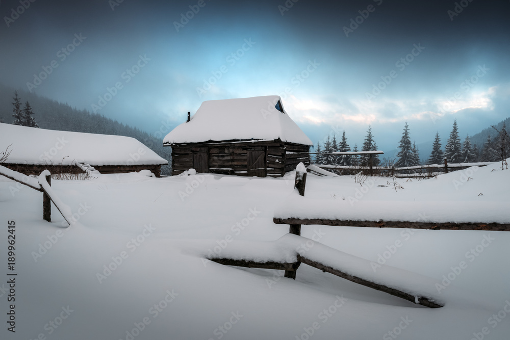 Fantastic winter landscape with wooden house in snowy mountains. Christmas holiday concept. Carpathi