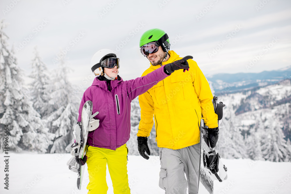 一对年轻夫妇寒假在雪山上滑雪板行走