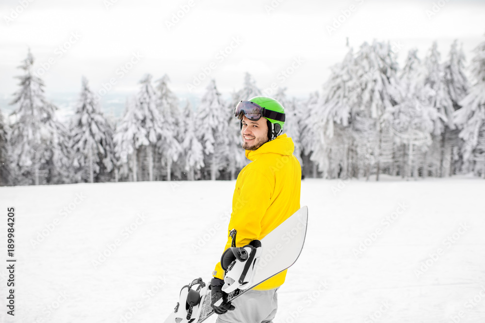 穿着冬季运动服的男子在雪山上滑雪板行走