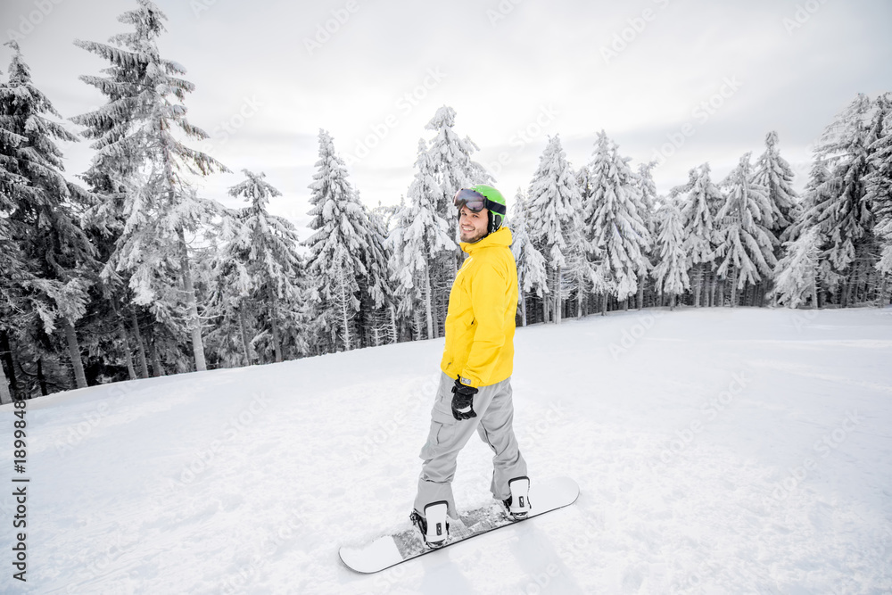 穿着五颜六色运动服的男子在有美丽树木的雪山上滑雪