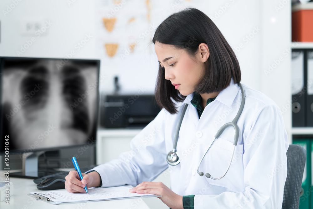 The doctor is sitting in the room to see the patient. She is opening x-ray effects.