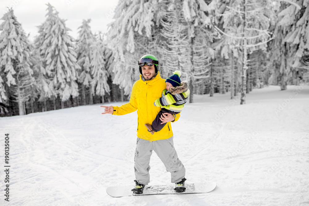 穿着五颜六色运动服的男子在有美丽树木的雪山上滑雪