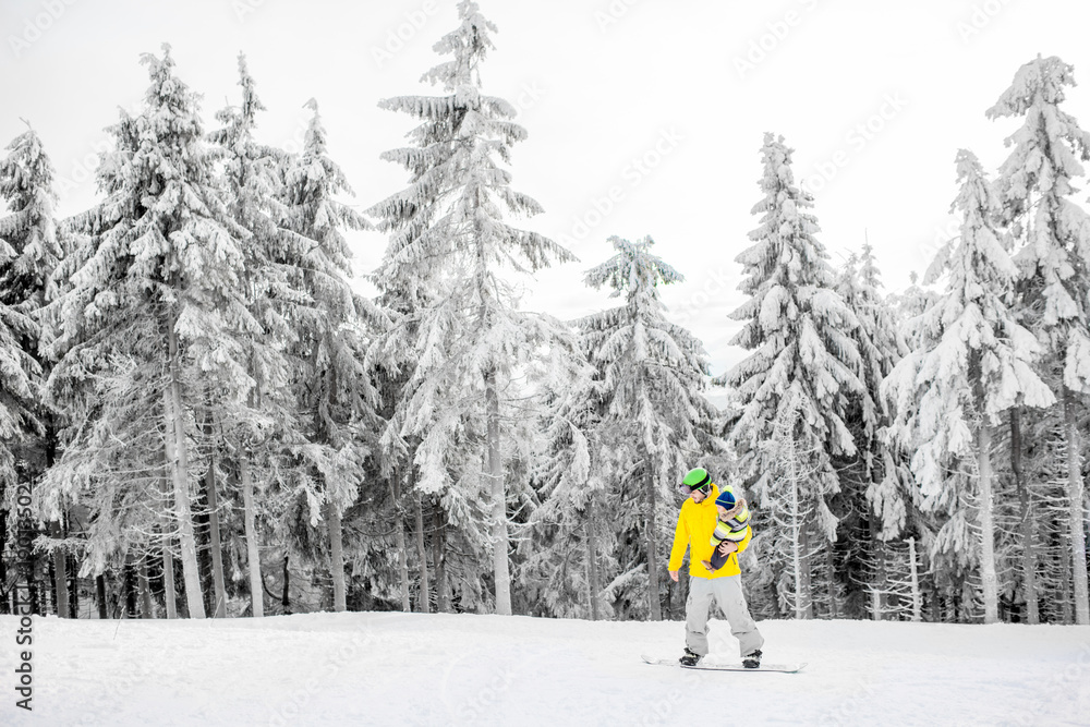 穿着五颜六色运动服的男子在有美丽树木的雪山上滑雪