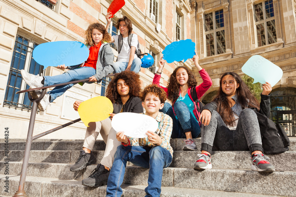 Happy teenage boys and girls with speech bubbles