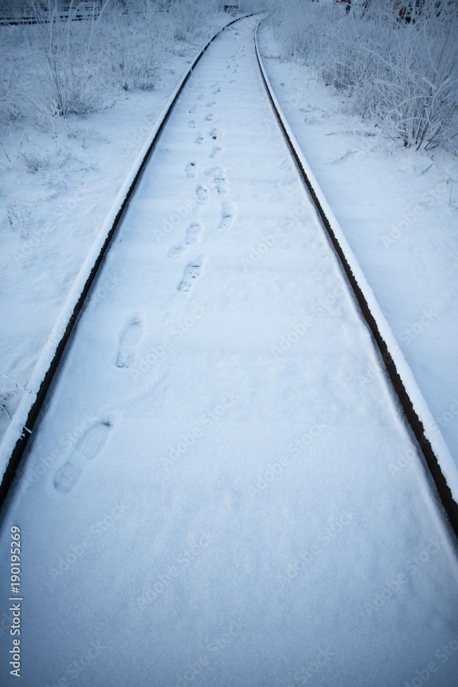 冬天的铁轨，雪地上的脚步向前