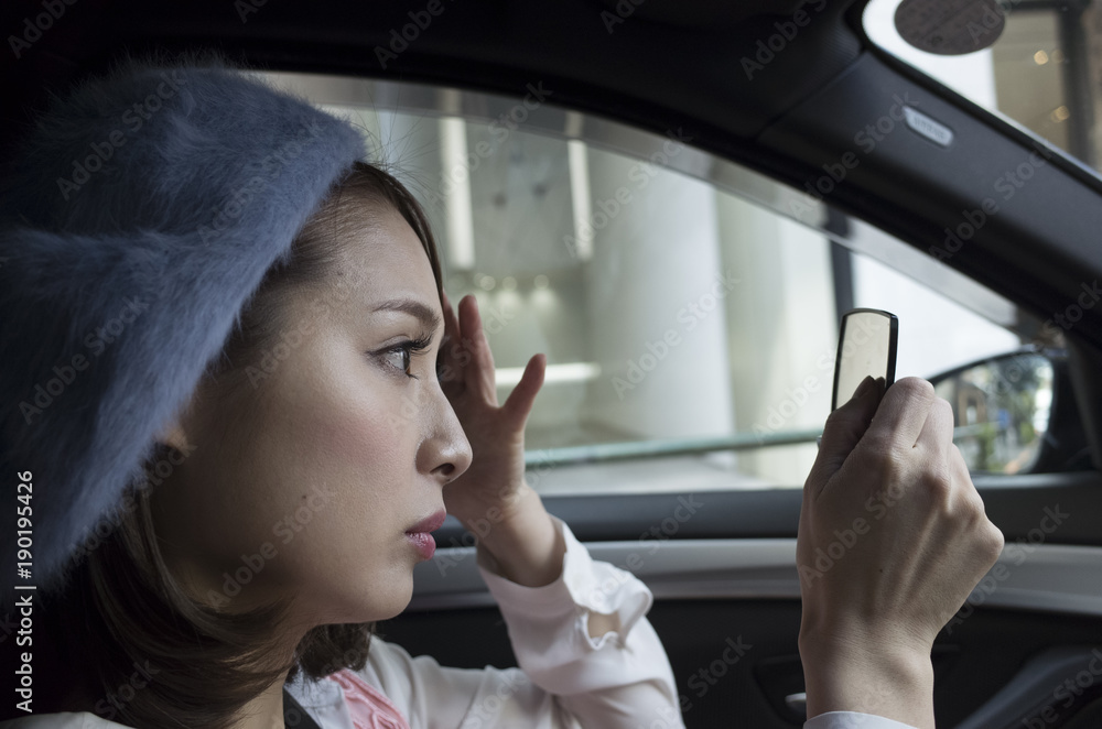 女性は車内でメイク直しをしている