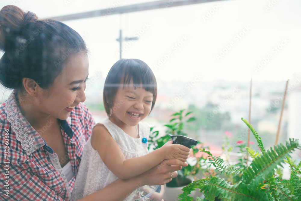 母亲和蹒跚学步的女儿春季园艺