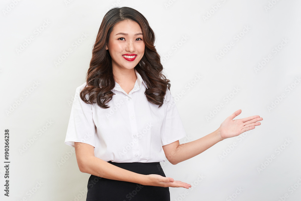 Young asian woman making displaying posing and showing thumb up gesture presenting empty area