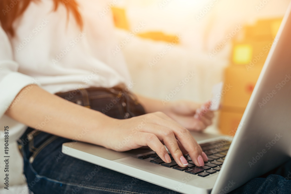 Young asian girl is freelancer with her private business at home office, working with laptop, coffee