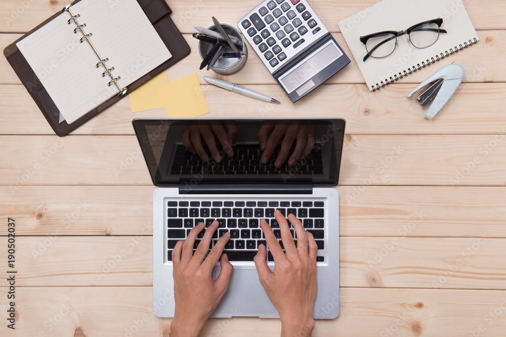 Top view of man using a modern portable computer in home office