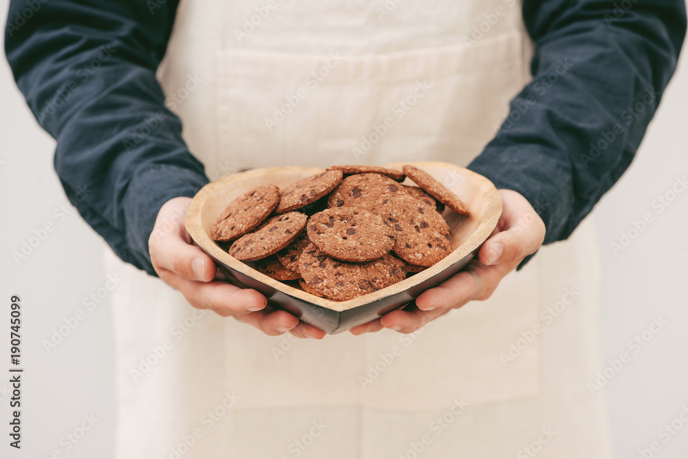 Homemade chocolate cookies on plate in male hands.