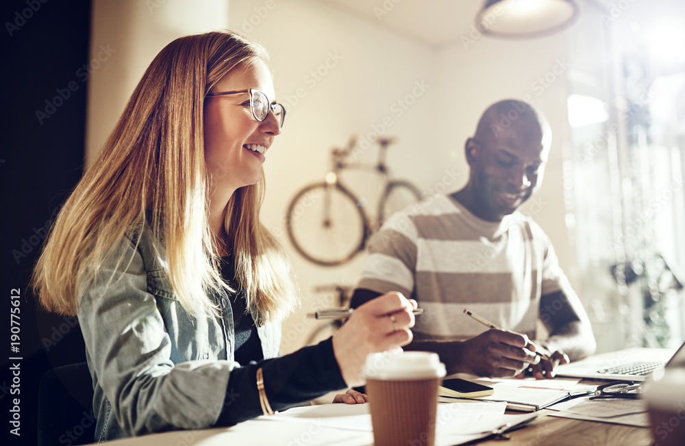 Diverse office colleagues smiling and working together in an office