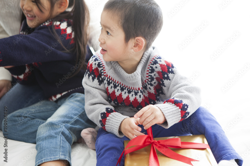 お母さんと、大きなプレゼントを開ける男の子と女の子。