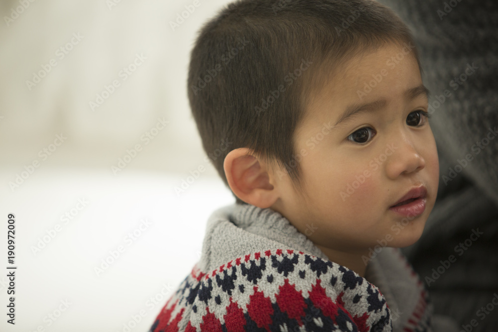 セーターを着た、かわいい男の子のアップ。