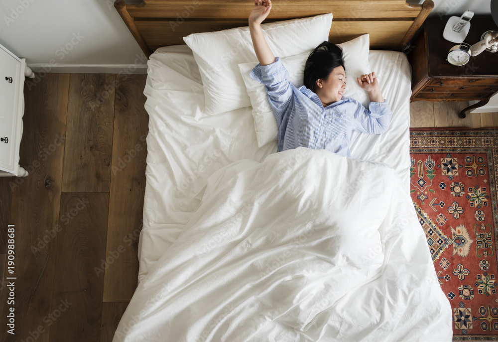 Asian woman on the bed waking up in the morning