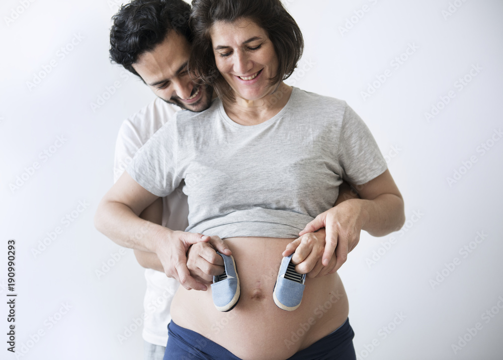 Caucasian couple holding baby boy shoes