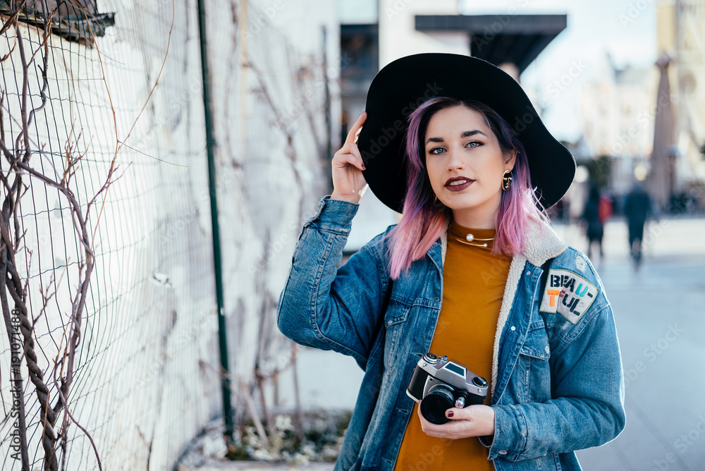 Portrait of a hipster girl with a hat at city street.