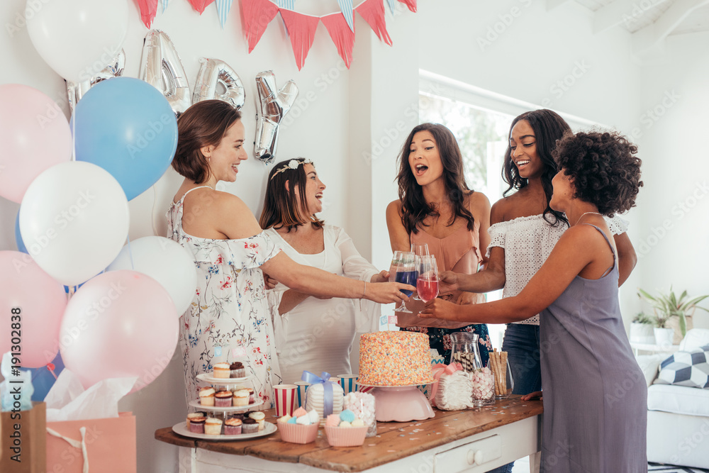 Women toasting with juices at baby shower party