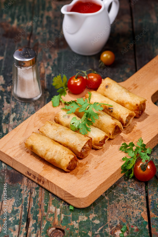 Vietnamese food. Delicious homemade spring rolls on wooden table.