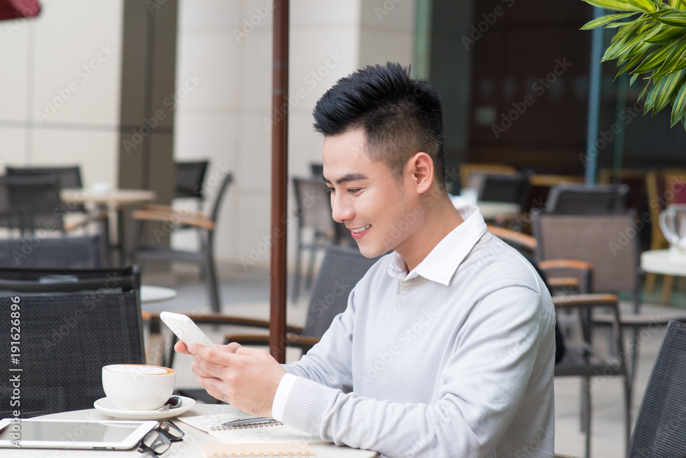 年轻的商人在咖啡休息时坐在咖啡馆里。