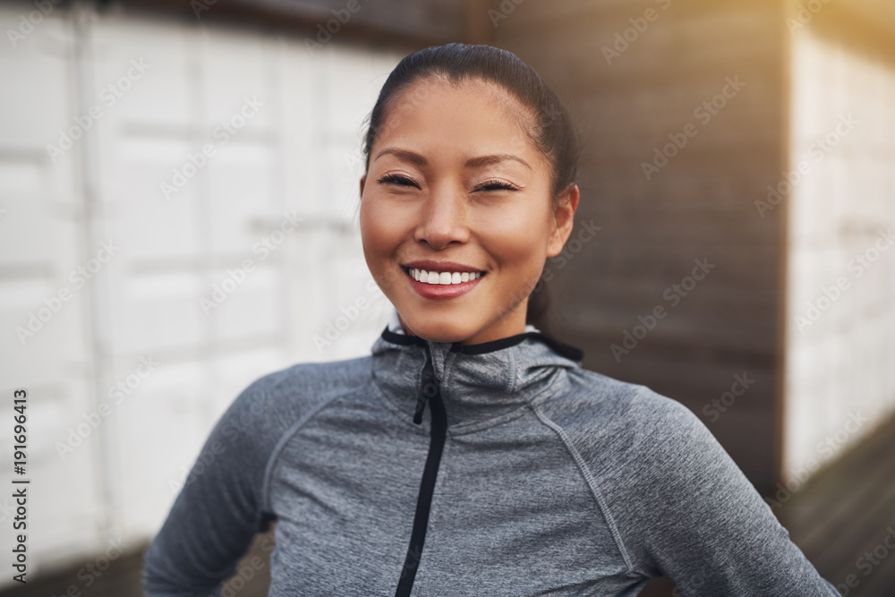 穿着运动服微笑的亚洲年轻女子外出跑步