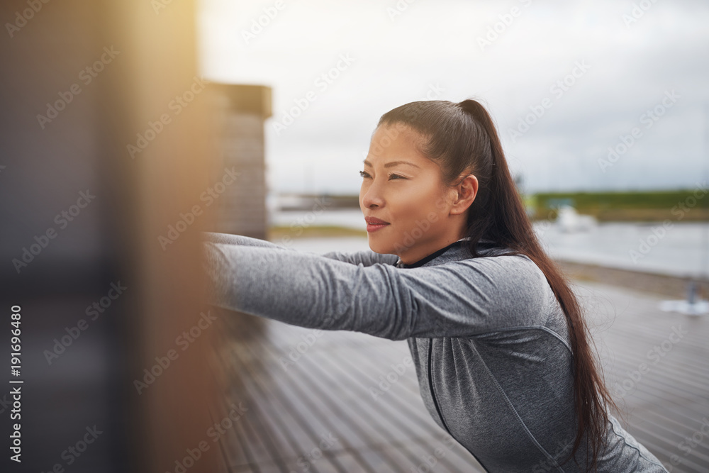 专注于慢跑前户外伸展运动的年轻亚洲女性