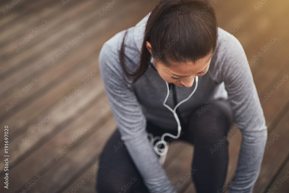 年轻的亚洲女子在慢跑前把跑步者绑起来