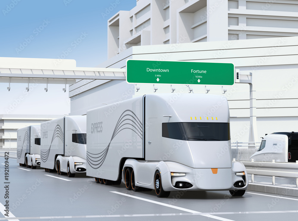 A fleet of self-driving electric semi trucks driving on highway. 3D rendering image.