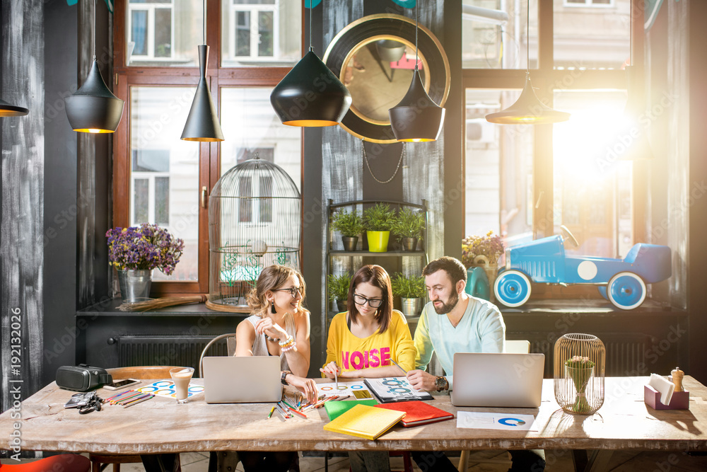 Group of caucasian coworkers dressed casually working together with documents and laptops at the big