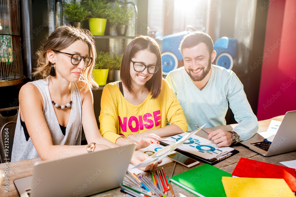 Group of caucasian coworkers dressed casually working together with documents and laptops at the big