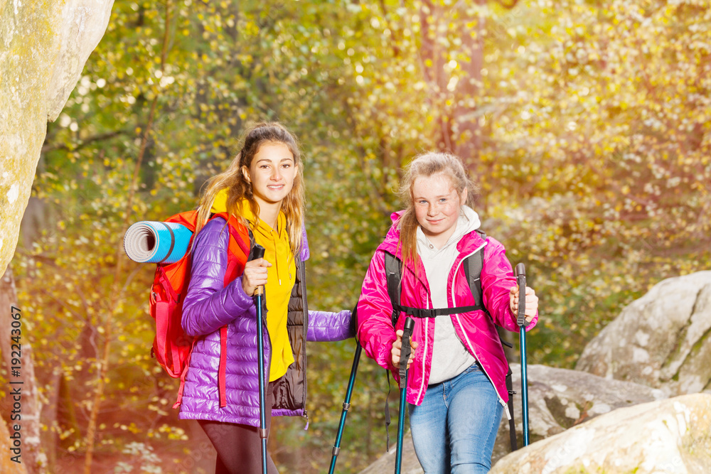 Hikers with trekking sticks at sunny day outdoors