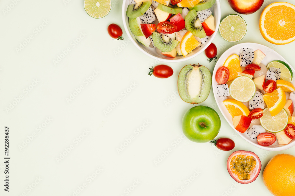 Bowl of healthy fresh fruit salad on wooden background. Top view.