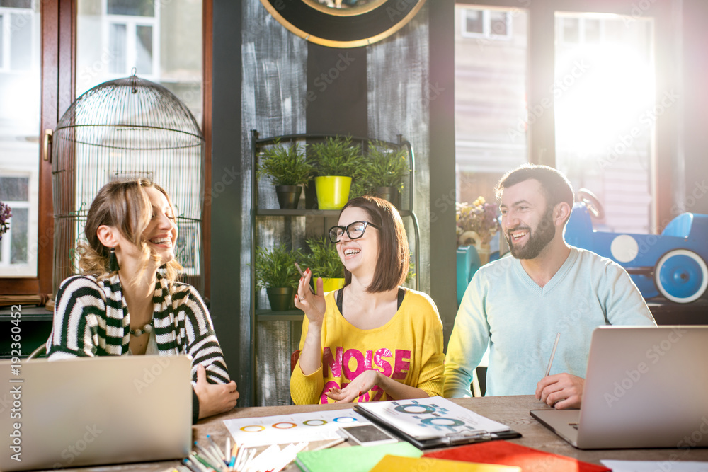 Group of caucasian coworkers dressed casually working together with documents and laptops at the big