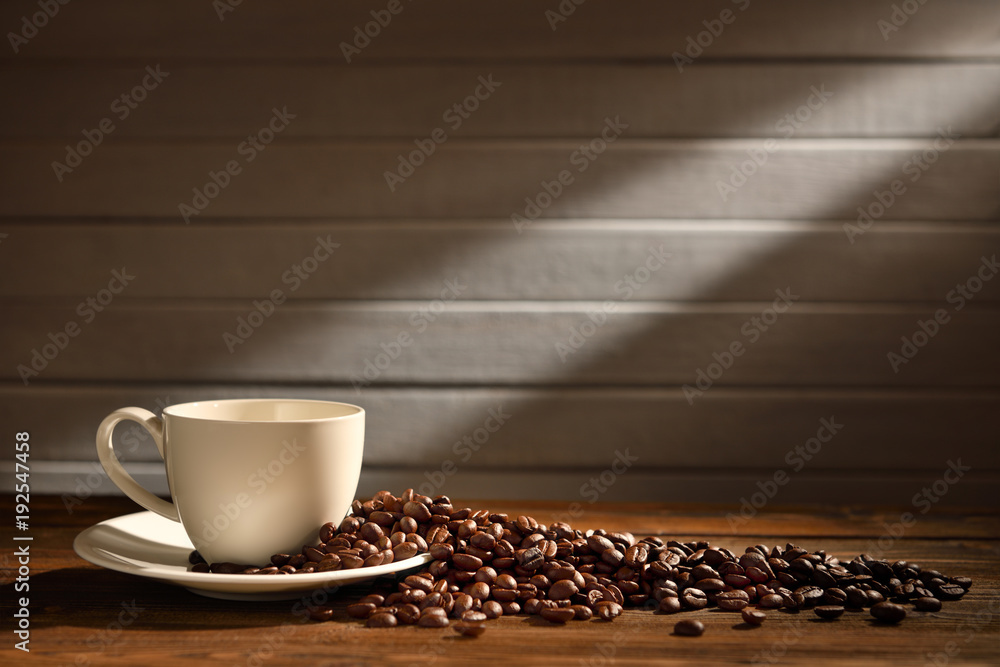 Coffee cup and coffee beans on old wooden background