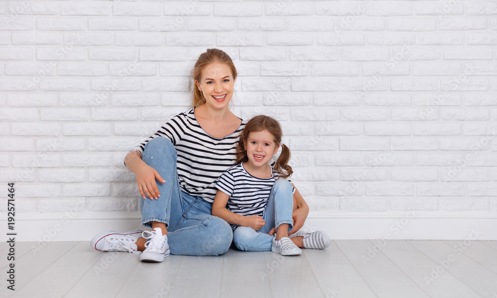 happy family mother and child daughter near an empty wall