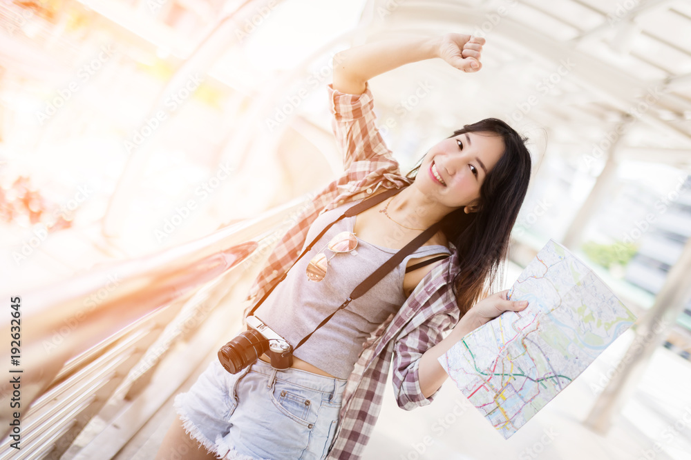 beautiful happiness young asian girl in casual dress traveling alone at train station or airport wit